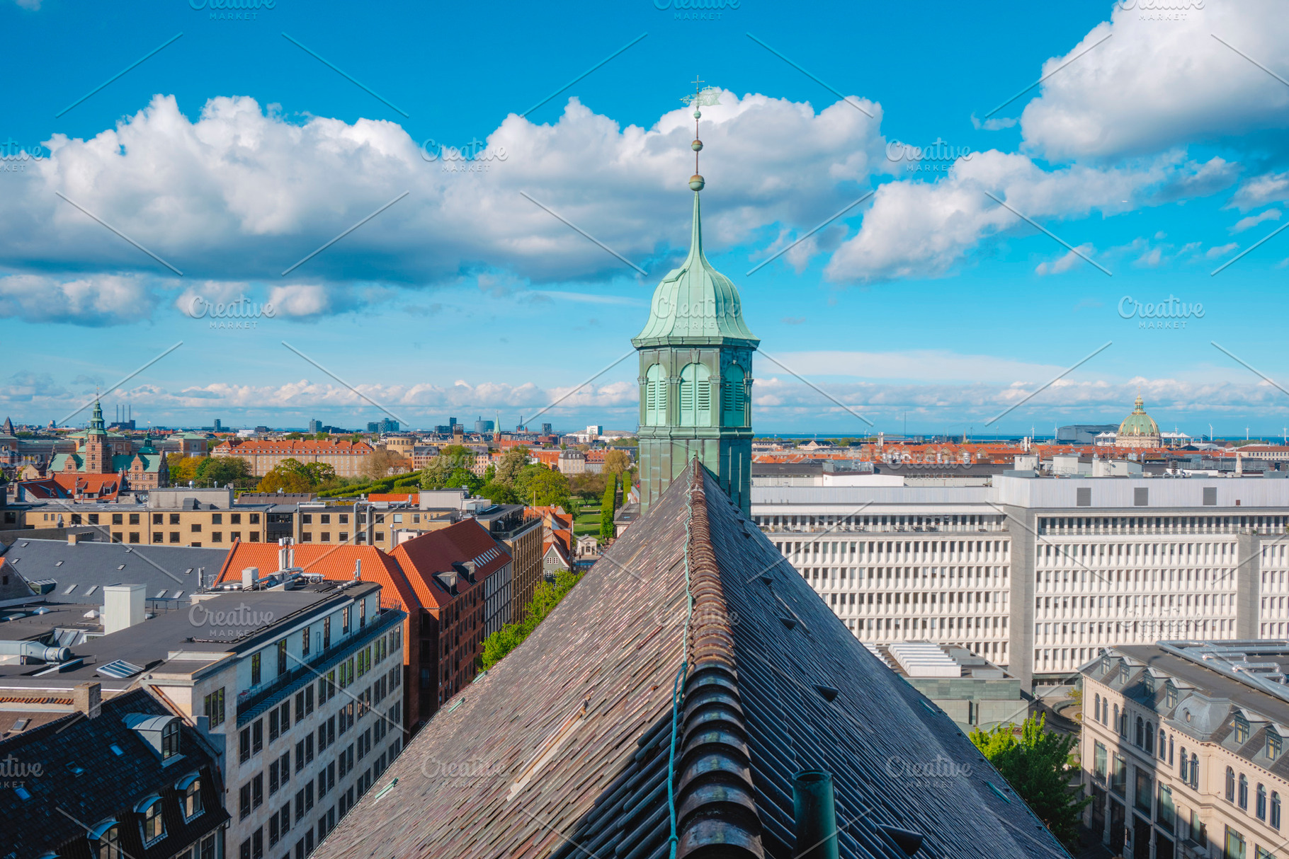 Trinitatis Church spire over Copenhagen rooftops, a Photo by Nito