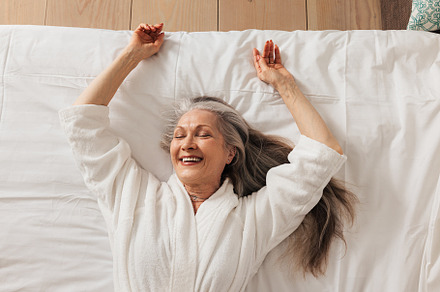 Happy aged woman in a bathrobe