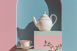 Pastel still life with teapot, teacup, macaron, and flowers arra, a Photo by Studio ANNA