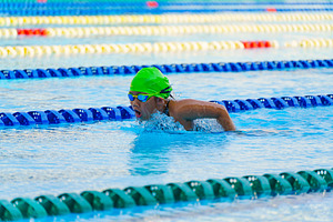 Swimmer child swims butterfly swimming style in a race swimming