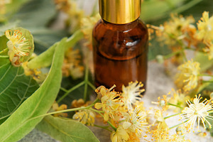 Linden essential oil in dropper bottle with fresh flowers, a Health & Medical Photo by Olena Rudo