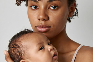 Woman with baby portrait showing protective embrace, a Person Photo by GoodGoods