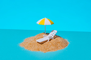 a tiny beach setup on a blue surface, a Photo by Nito