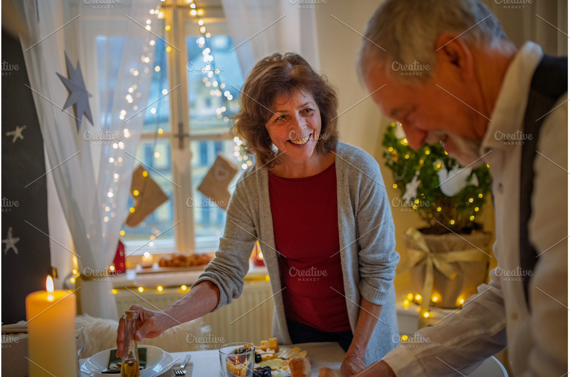 Older couple preparing table for, a Holiday Photo by HalfPoint