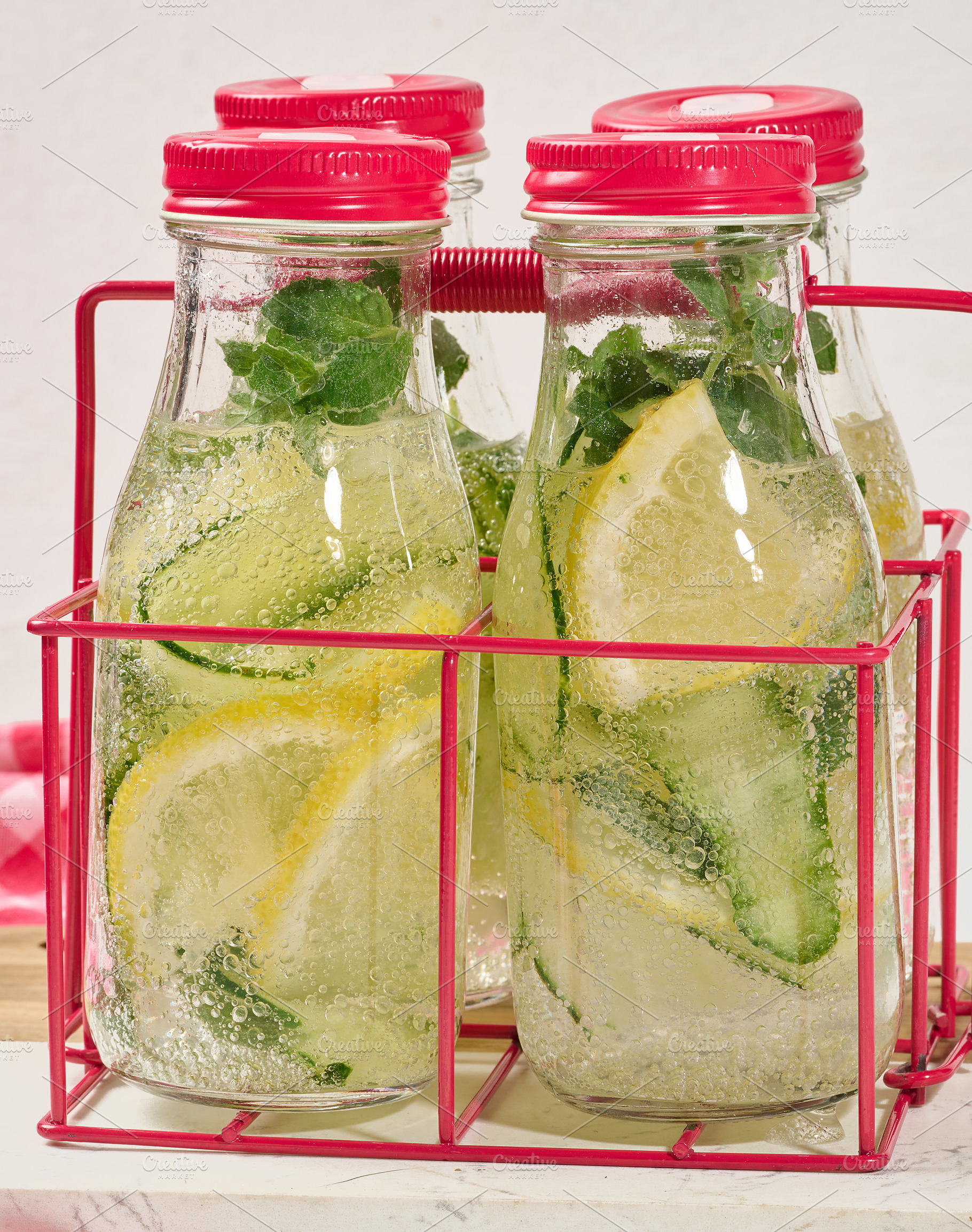 Glass bottles with red lids filled with detox water containing c, a Food & Drink Photo by ndanko