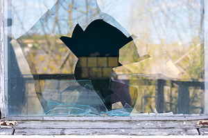 Shattered glass window with a large central hole, surrounded by, a Background Photo by Ales Munt
