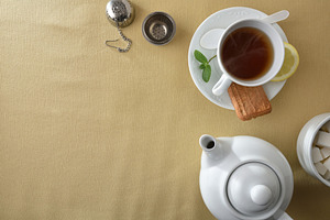 Tea and white ceramic containers on a table with tablecloth, a Food & Drink Photo by Davizro's Market