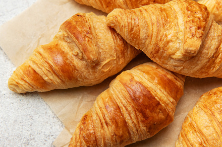 Freshly baked croissants with wheat on baking paper