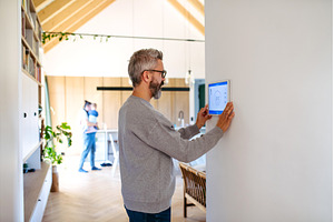 Man using smart home control panel., a Technology Photo by HalfPoint