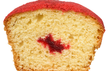 A cross section of a baked muffin red, jam filling visible in th