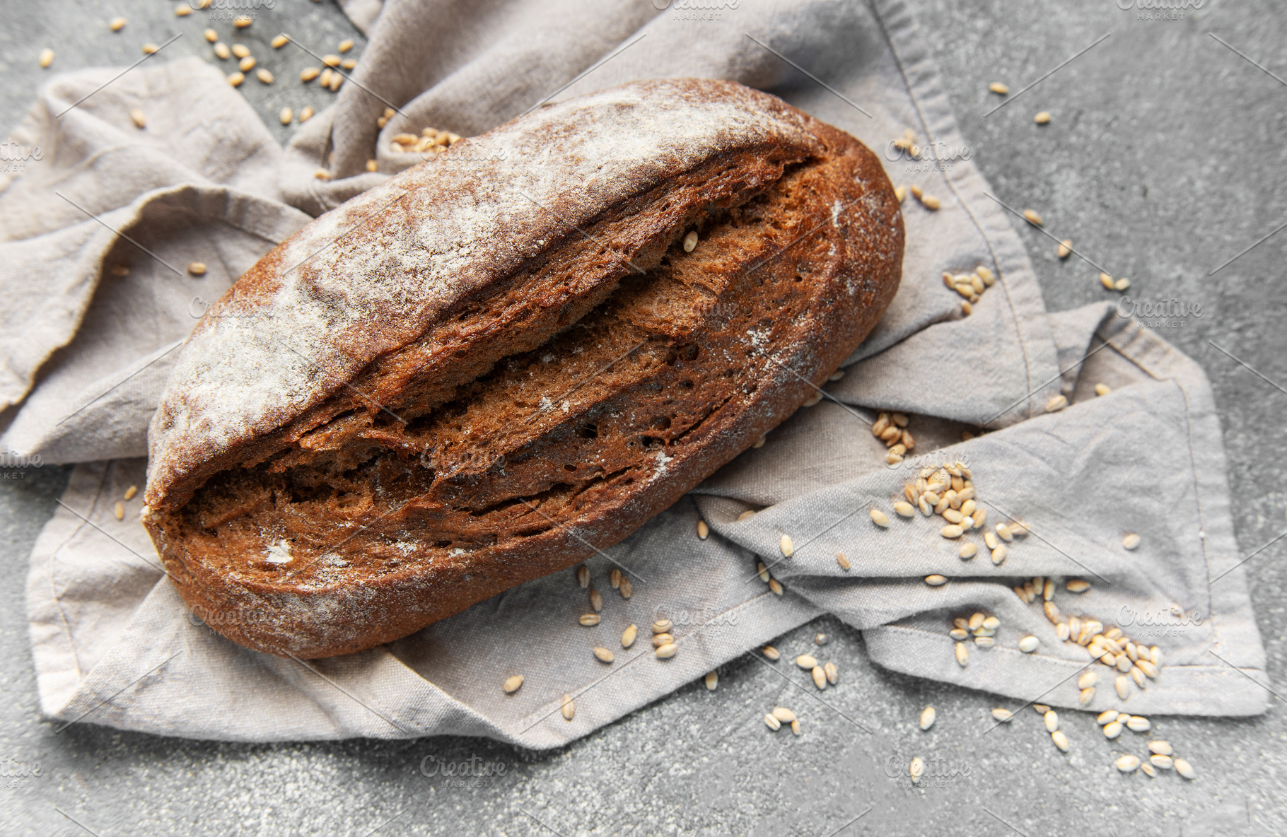 Rustic rye sourdough bread loaf on gray cloth, a Food & Drink Photo by Olena Rudo