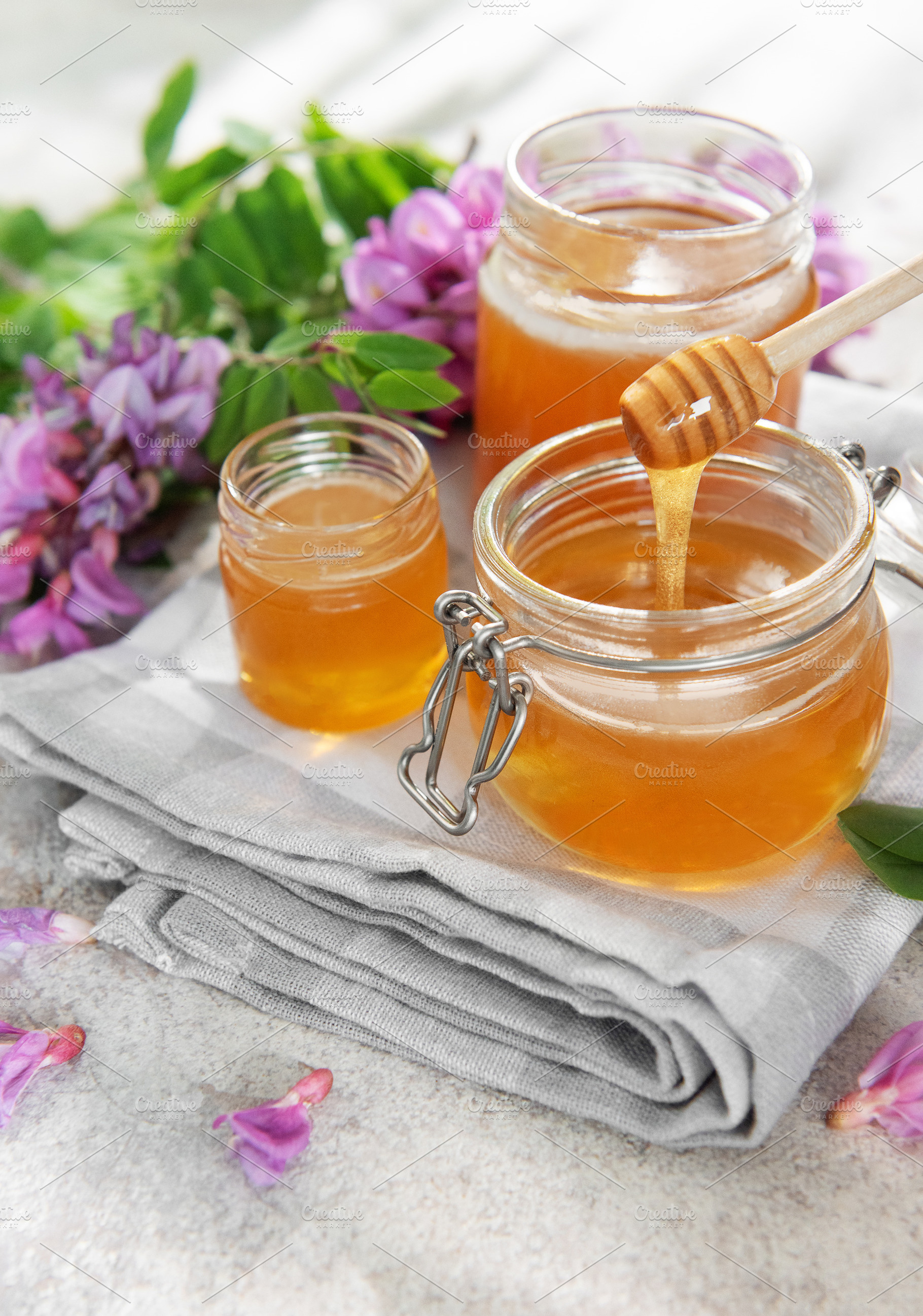 Honey in jars with dipper and acacia flowers, a Food & Drink Photo by Olena Rudo