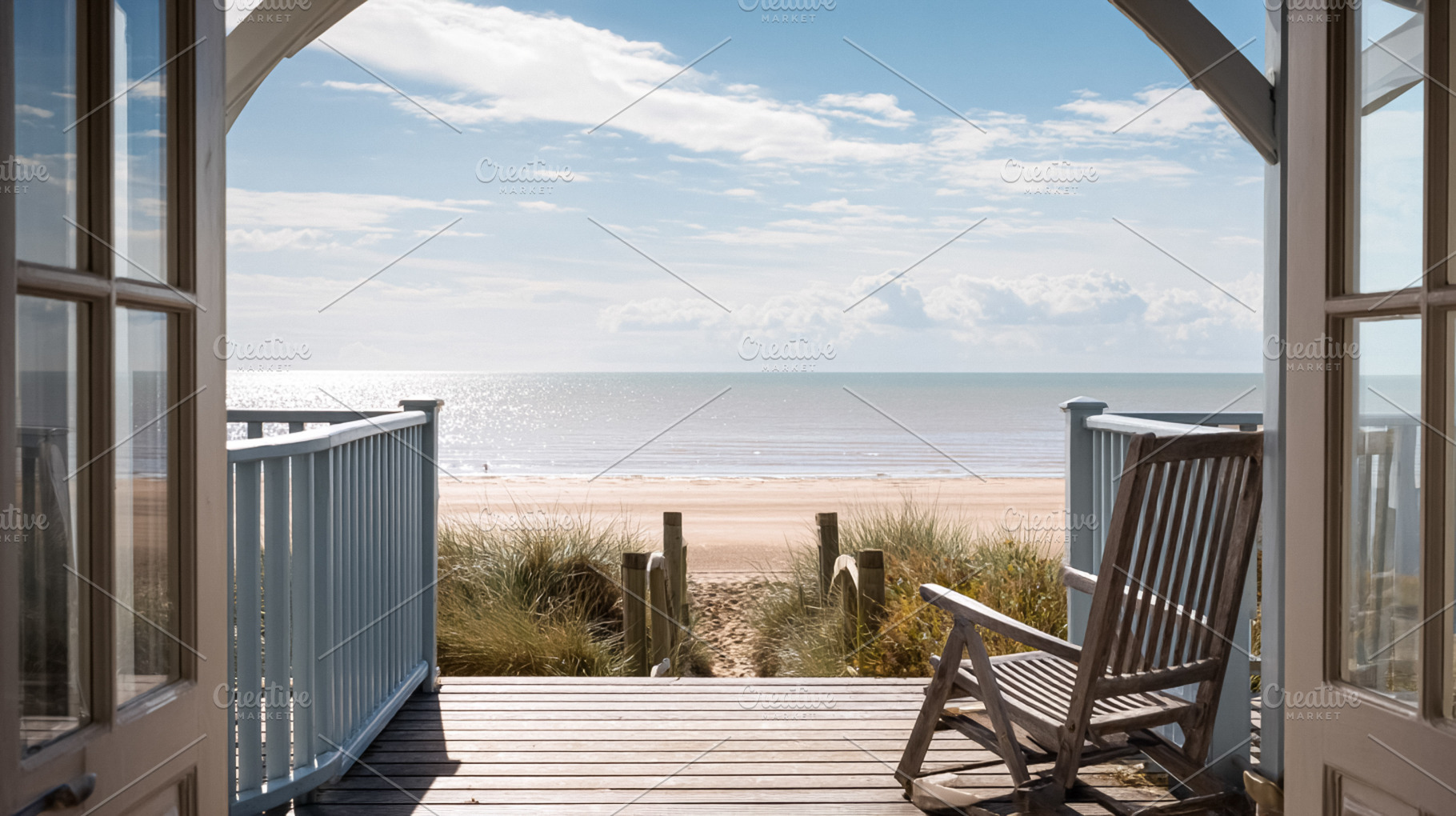 Wooden deck and open doors of a beach house offering a serene vi, a Photo by Studio ANNA