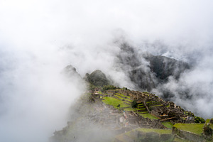 Panoramic view of Machu Picchu ruins surrounded by misty mountai, an Architecture Photo by GoodGoods