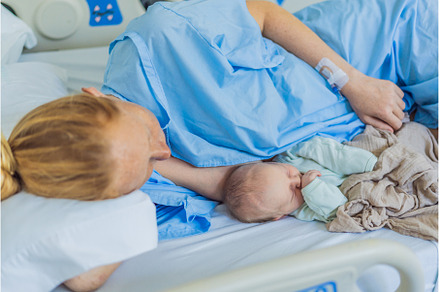 A baby lies with the mother after