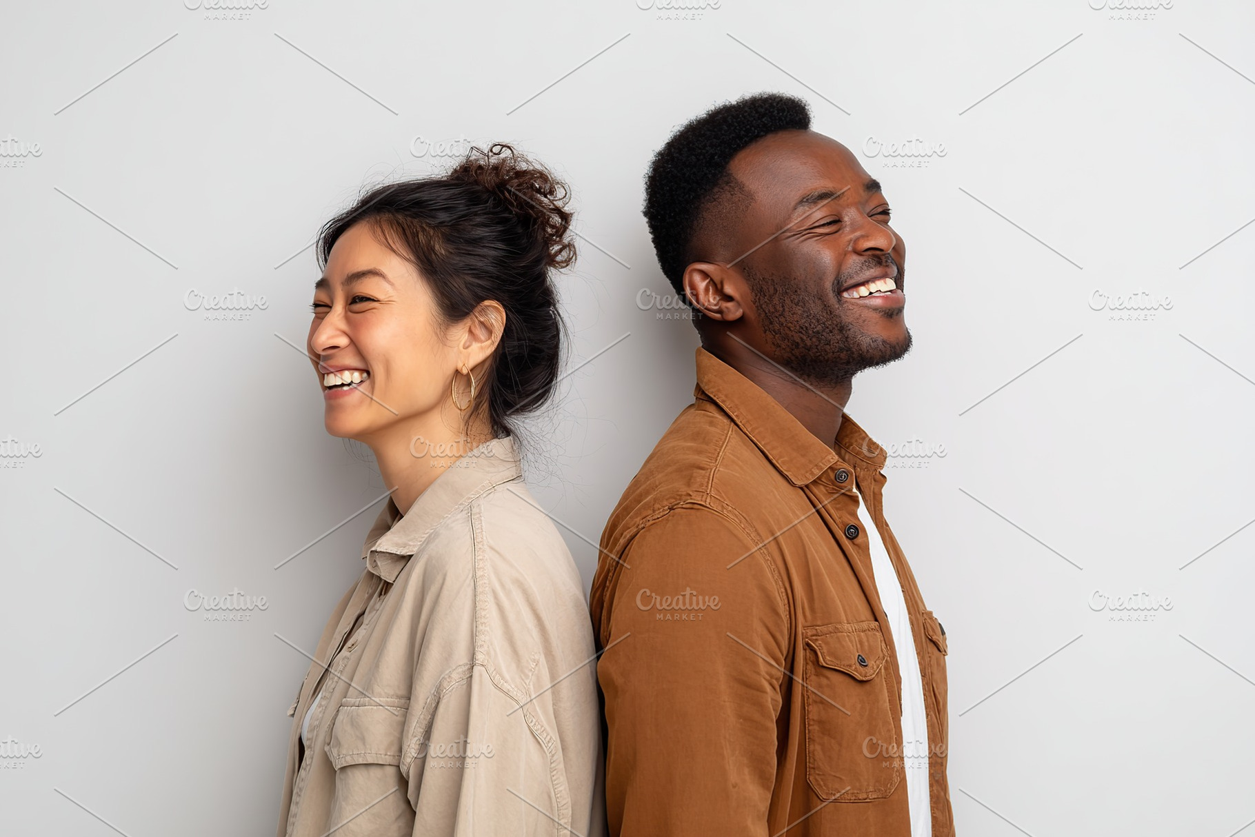 Friends sharing laughter while standing back to back in a studio setting, a Photo by AlyaAnd