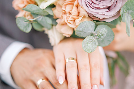 Bouquet of flowers containing rings, wed, and wedding rings