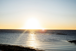 Sunset over the tranquil ocean viewed from the shore in Iceland, a Nature Photo by AS photostudio