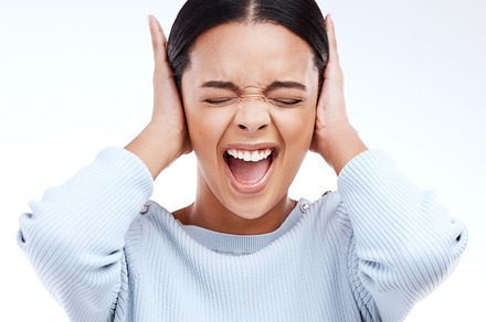Shouting, woman and hands on ears for noise, silence and denial gesture on studio white background. Headache, face and angry girl in pain, ignoring and deaf, wtf and emoji, frustrated and annoyed, a Photo by Peopleimages.com