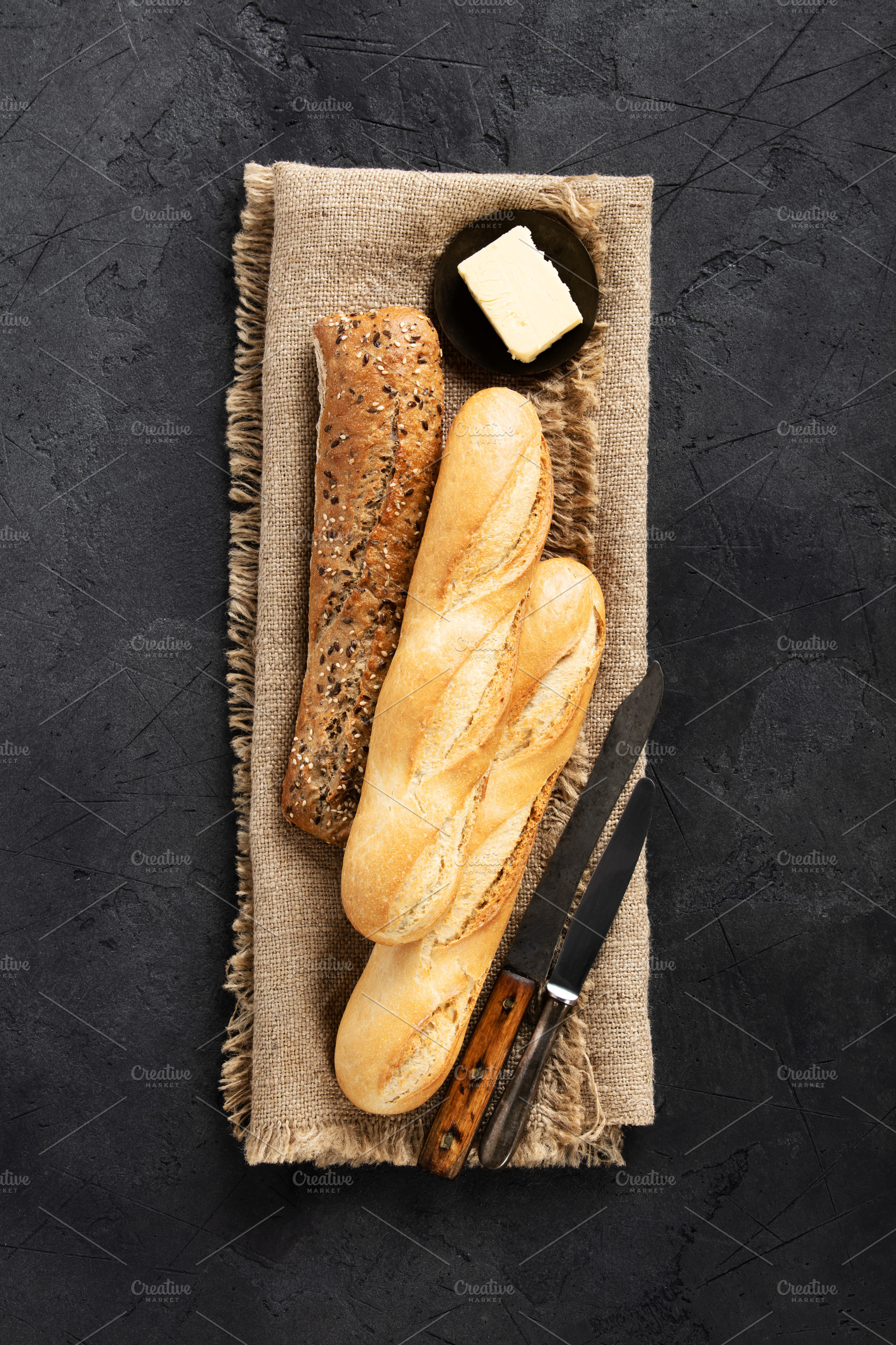 Assorted Baguettes on Burlap with Rustic Knife and Dark Backgrou, a Food & Drink Photo by Natalia Klenova's Shop