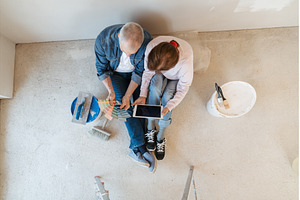 Senior couple renovating their home, a Person Photo by HalfPoint