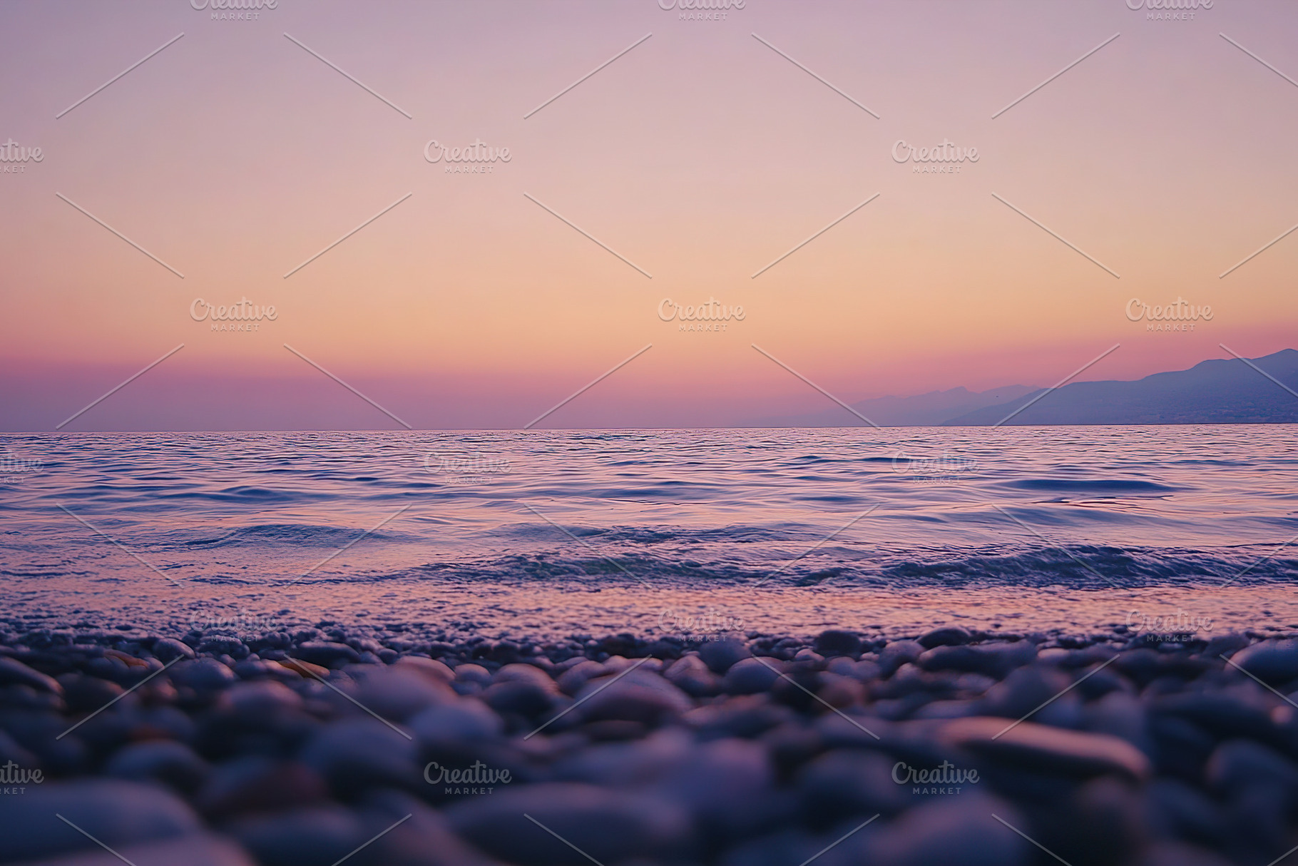 Stunning sunset over the calm sea with gentle waves and colorful sky, a Wallpaper Photo by AlyaAnd