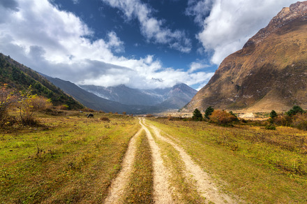 Mountain dirt road at sunset in summer. Himalayan mountains, a Nature Photo by den-belitsky