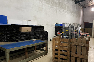 Industrial bottling workshop with machinery and storage racks, a Photo by AS photostudio