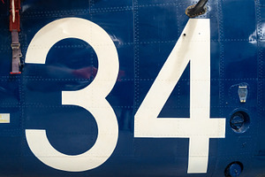 Blue aircraft fuselage with white number 34 and metal details, a Background Photo by GoodGoods
