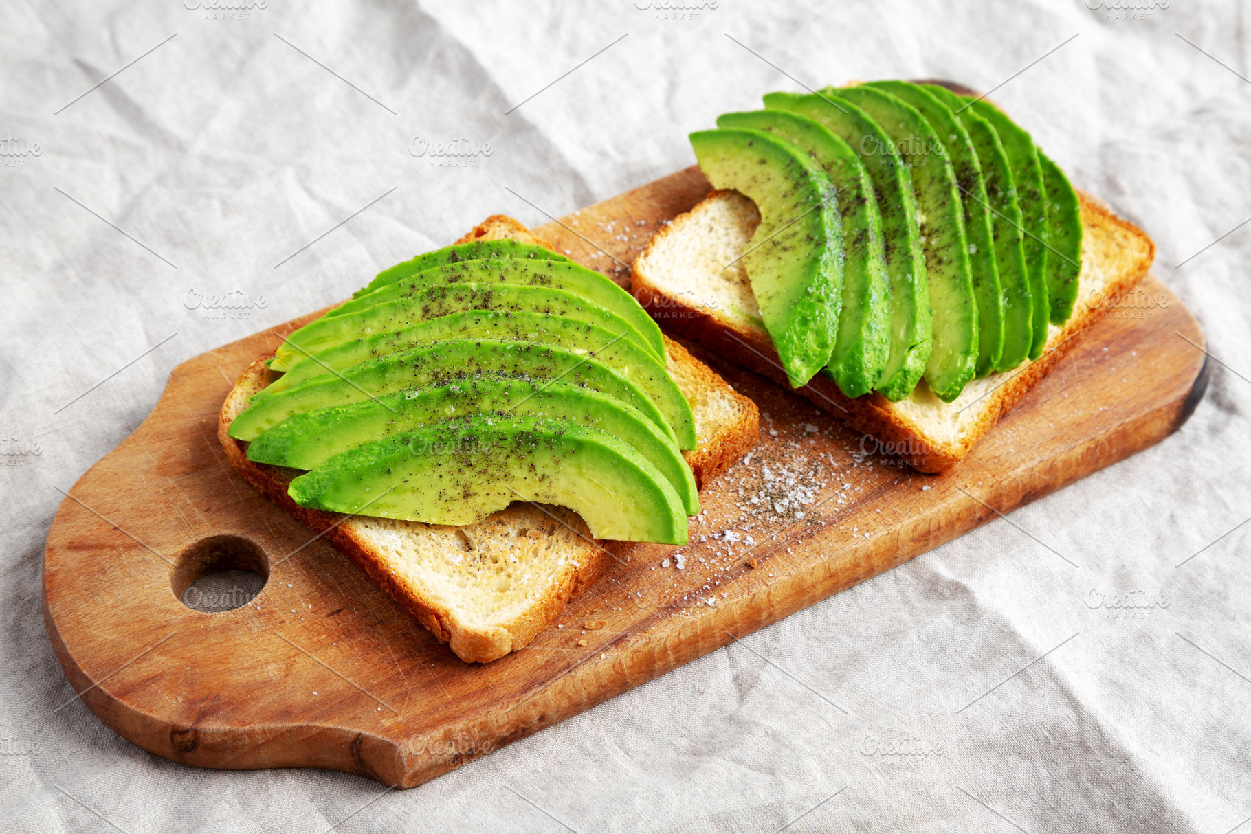 Homemade Avocado Toast on a rustic wooden board, side view., a Food & Drink Photo by LiudmylaChuhunova