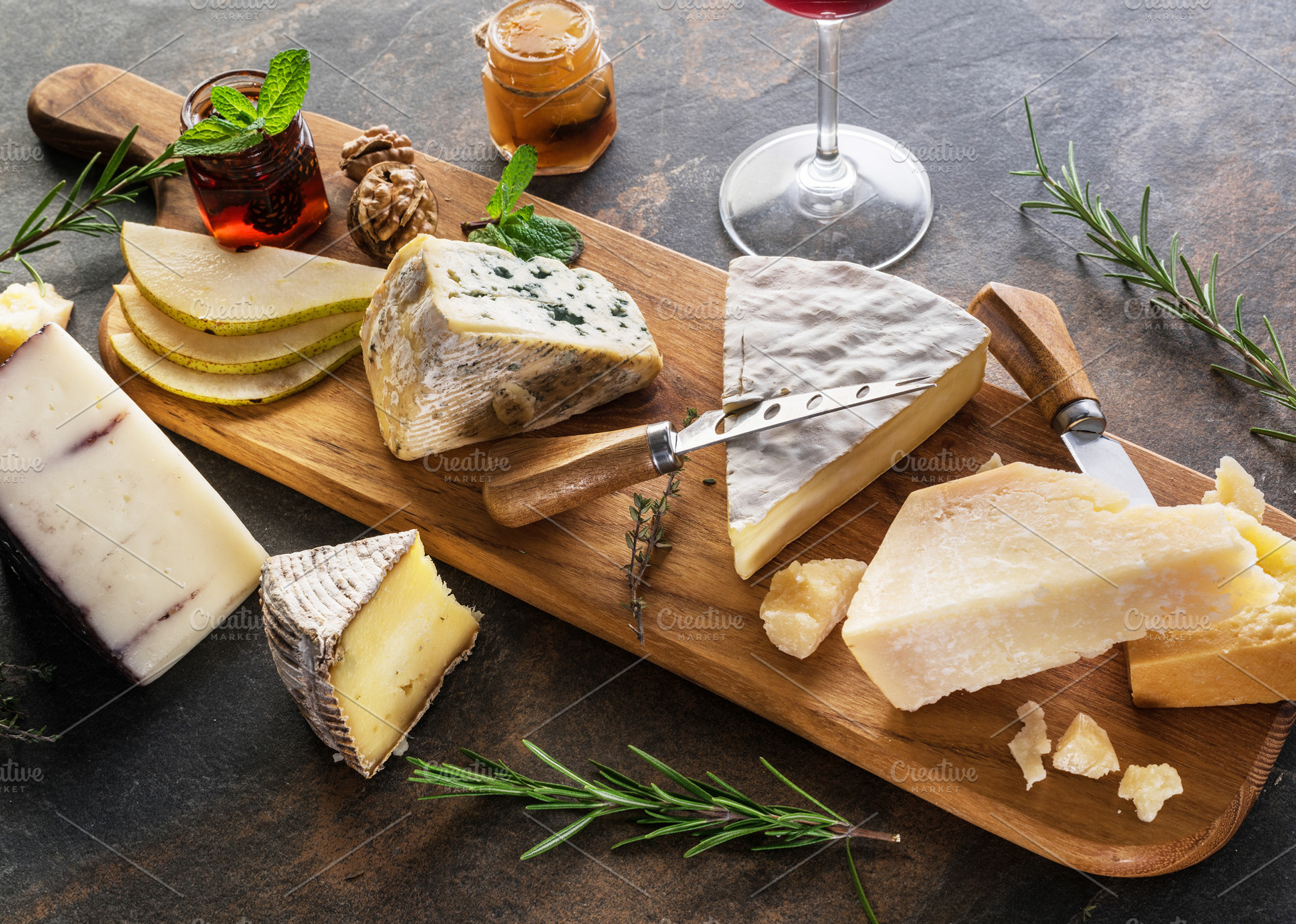 Cheese assortment with nuts and jams on stone board.Top view., a Food & Drink Photo by Volff