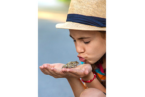 The child is playing with the frog, a Nature Photo by yanadjana