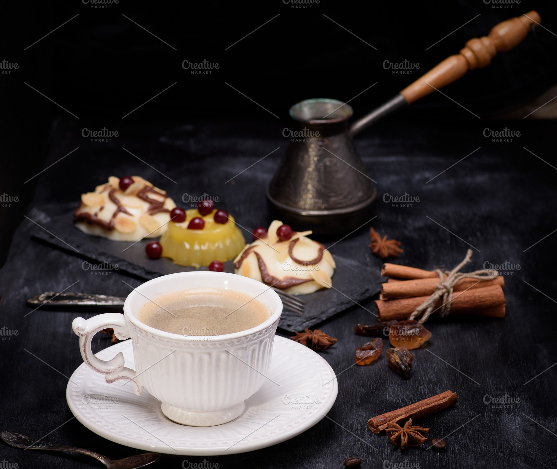 A cup of coffee with desserts, a cezve and cinnamon on a black b, a Food & Drink Photo by ndanko