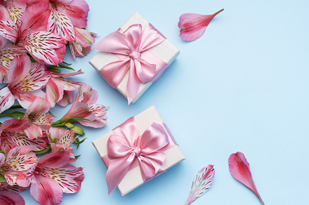 Beautiful Alstroemeria flowers and gift boxes on blue background, a Holiday Photo by Olena Rudo