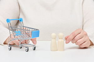 Hands are shown with a miniature shopping cart and two small woo, a Person Photo by ndanko