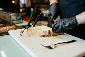 Chef cutting grilled meat during, a Food & Drink Photo by HalfPoint