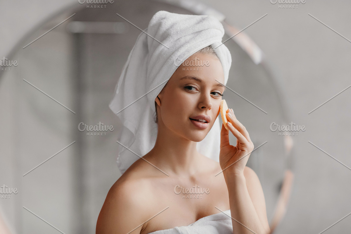 Moisturizing skin after shower. Pretty millennial woman in towel covering her e, a Photo by Prostock-Studio (Photo 3 of 3)
