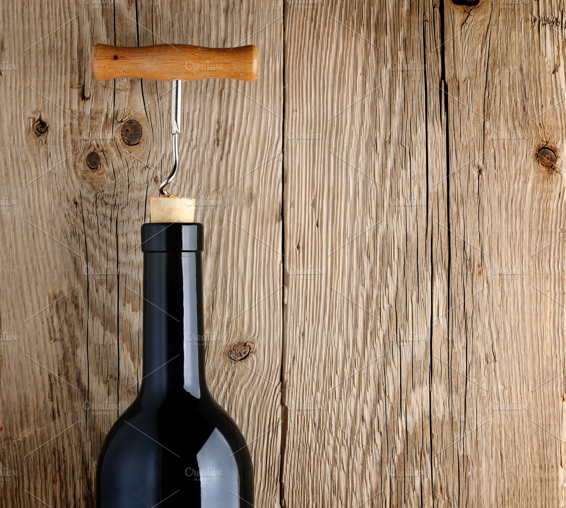 Bottle of wine with corkscrew featuring bottle, wine, and glass