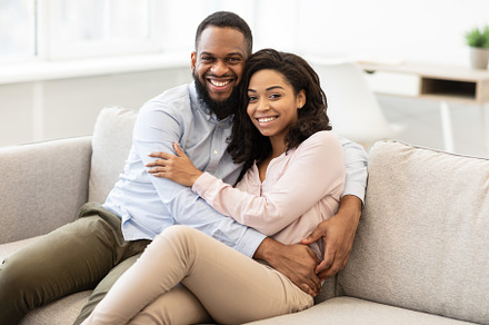 African american couple spending weekend together lying on sofa, a Photo by Prostock-Studio