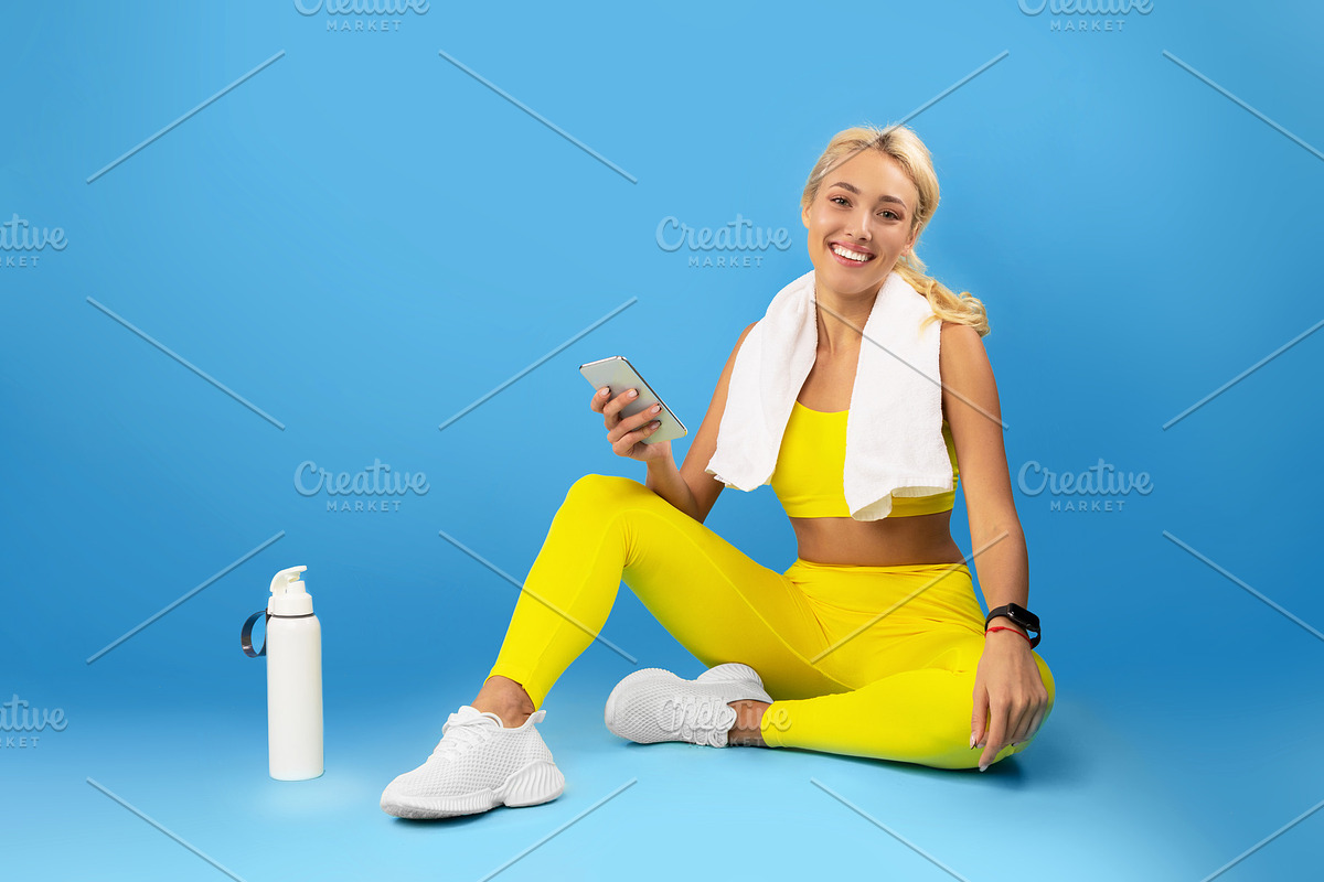 Sporty smiling woman using cellphone at studio, a Photo by Prostock-Studio (Photo 1 of 2)