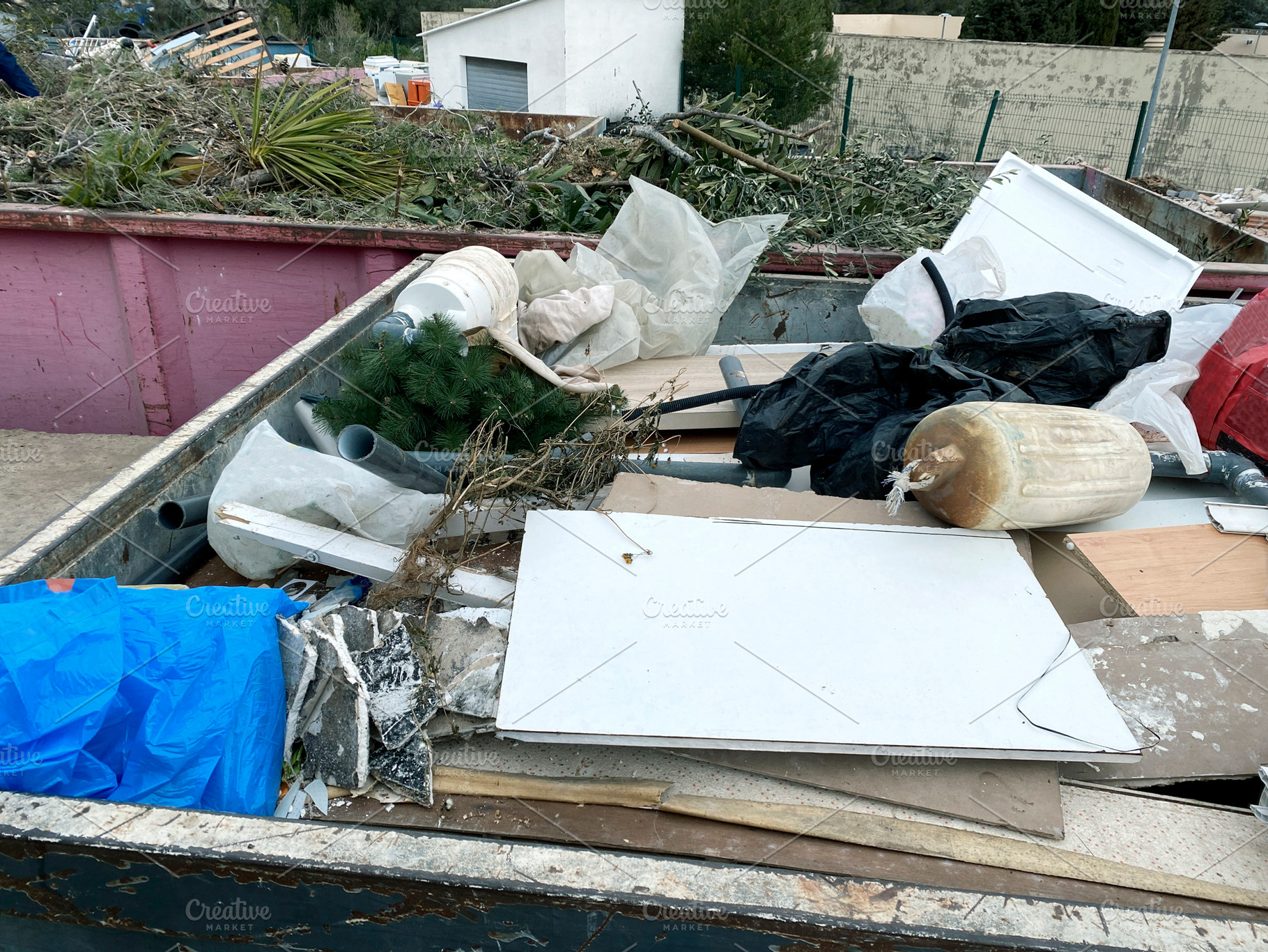 a container filled with bulky waste at a recycling site, a Photo by Nito