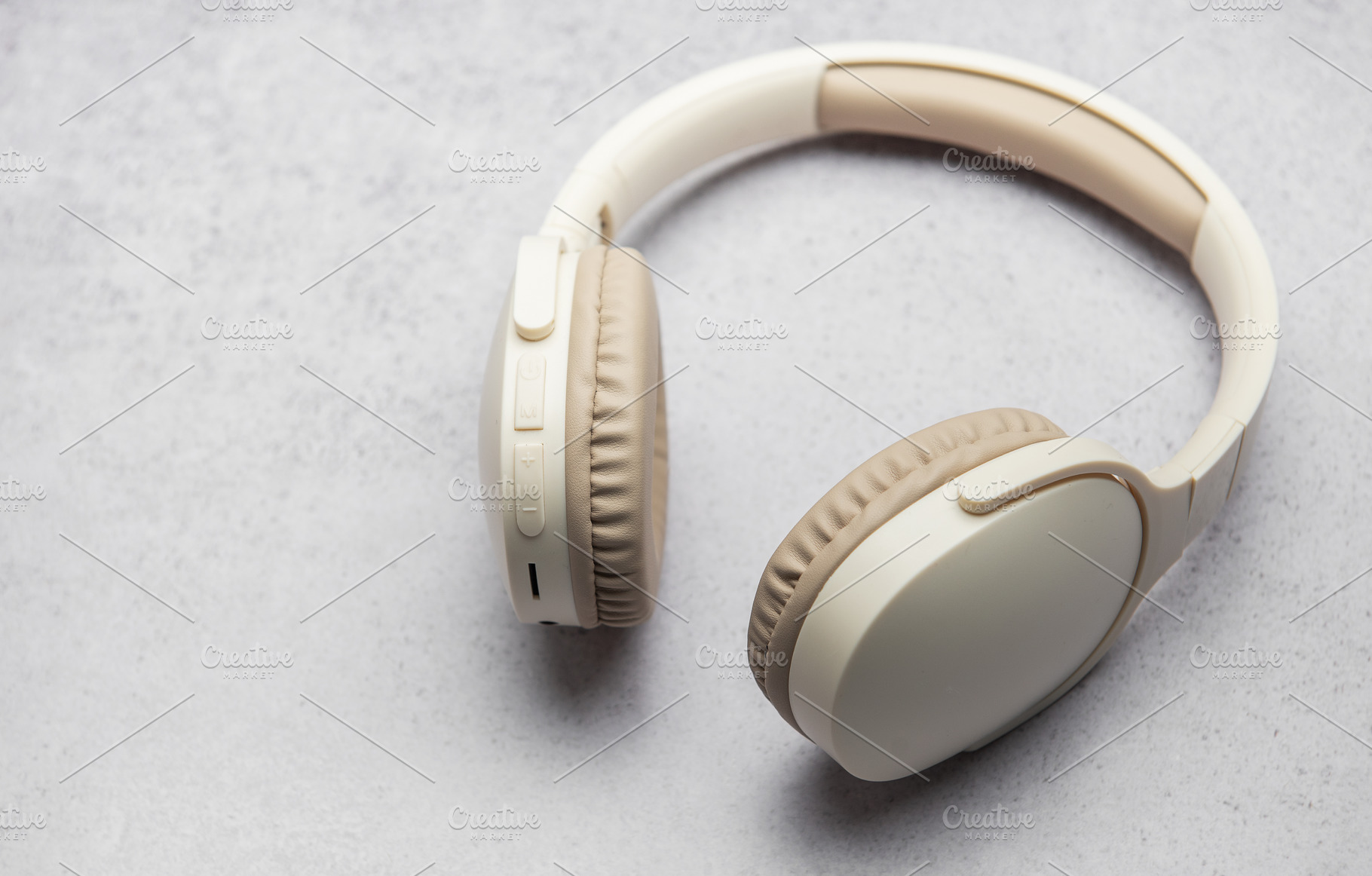 Modern wireless headphones lying on gray marble table, a Technology Photo by Olena Rudo