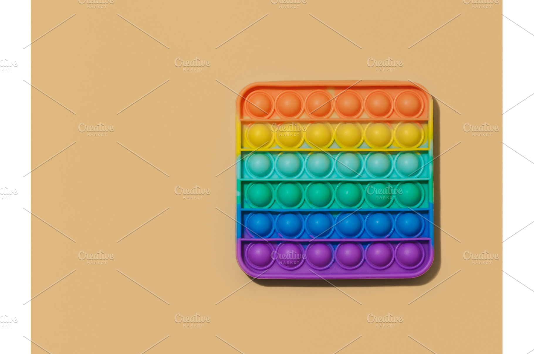 Popit toy on pastel beige background, a School & Education Photo by Fascinadora