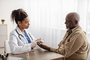 Emergency call system. Doctor giving Alarm Button to Senior Man, a Photo by Prostock-Studio