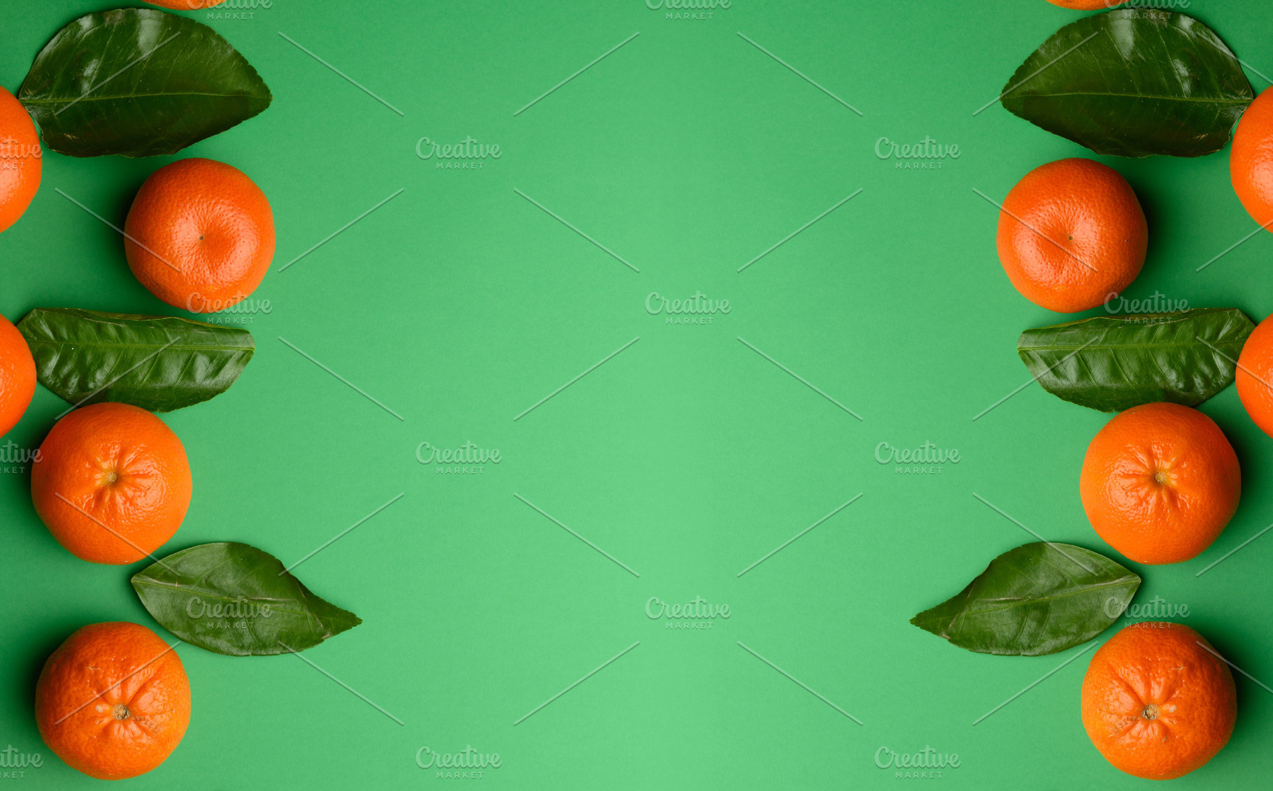 Ripe tangerines with green leaves on a bright green background,, a Food & Drink Photo by ndanko