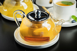 Fruit tea with mango and mint in a glass teapot on the table, a Food & Drink Photo by Budarinphoto