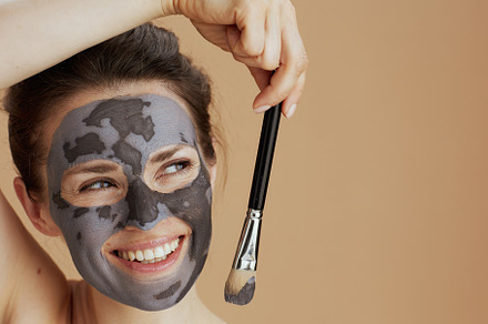 smiling modern 40 years old woman with brush and cosmetic mask, a Photo by Alliance Images