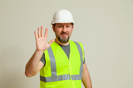 worker in a vest and white helmet, a Person Photo by Photostock