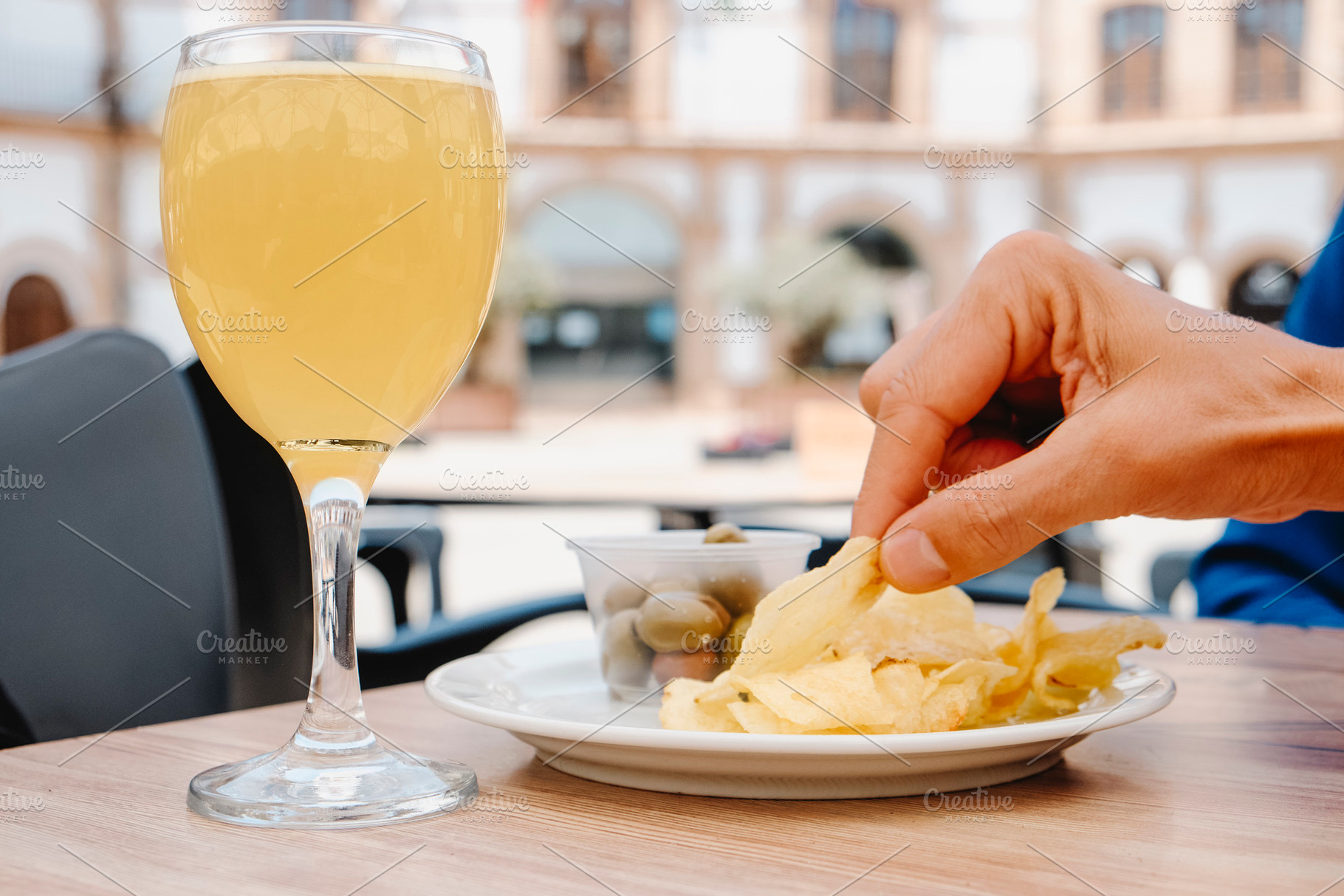 man about to eat a potato chip at an outdoor table, a Photo by Nito