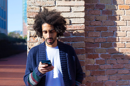 Young afro man using cellphone outdoor, a Person Photo by 2Design